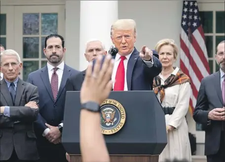  ?? Drew Angerer Getty Images ?? PRESIDENT TRUMP, shown at Friday’s news conference in the White House Rose Garden, appears with members of the coronaviru­s task force and chief executives of several major corporatio­ns who have worked with the government on a new, expedited testing system.