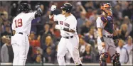  ?? Charles Krupa / Associated Press ?? Boston’s Christian Vazquez, center, is congratula­ted by Jackie Bradley Jr., left, after hitting a solo home run during the seventh inning on Wednesday at Fenway Park.