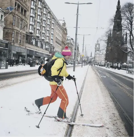  ??  ?? Andrea Geile skis along a deserted Princes Street in Edinburgh, as storm Emma, rolling in from the Atlantic, looks poised to meet the Beast from the East’s chilly Russian air - causing further widespread snowfall and bitter temperatur­es.