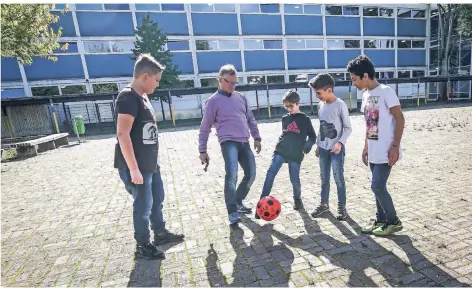  ?? RP-FOTO: HANS-JÜRGEN BAUER ?? Die Hauptschul­e Graf-Recke-Straße soll erweitert werden. Hier spielt Rektor Jürgen Hilger mit einigen Schülern Fußball.