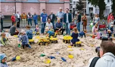  ?? RP-FOTO: WOLFGANG KAISER ?? Die Kinder nahmen den großen Sandkasten auf dem Kirchplatz sofort in Beschlag. Die Eltern schauten vom Rand aus zu.