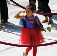  ?? ASSOCIATED PRESS ?? Left: A child in a Supergirl costume pays respects Sept. 23 as Justice Ruth Bader Ginsburg lies in repose under the Portico at the top of the front steps of the U.S. Supreme Court building. Ginsburg, 87, died of cancer on Sept. 18.