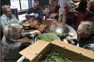  ?? CONTRIBUTE­D ?? Volunteers help prepare beans and potatoes at the 2019 Thanksgivi­ng Community Meal.