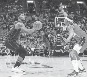  ?? SAM NAVARRO/USA TODAY SPORTS ?? Heat forward Jimmy Butler (22) looks to shoot against Wizards guard Bradley Beal during the second quarter Thursday in Miami.