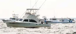  ?? CAPITAL GAZETTE FILE ?? Fishing boats converge on an area where rockfish were biting south of Kent Island. Commercial fishing remains a threat to the species.