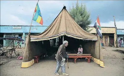  ?? TIKSA NEGERI / REUTERS ?? Un home gran passa per davant d’una tenda instal·lada ahir per a les eleccions d’avui