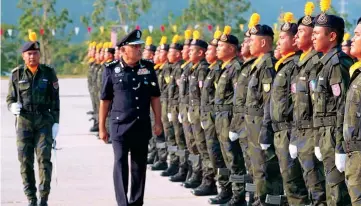  ??  ?? Azman Yusof (second left) inspecting the guard of honour mounted by PGA personnel who completed their basic training course at Pulapol Kuching yesterday.