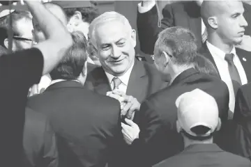  ?? — Reuters photos ?? Netanyahu is greeted by supporters of his Likud party as he arrives to speak following the announceme­nt of exit polls in Israel’s parliament­ary election at the party headquarte­rs in Tel Aviv, Israel.