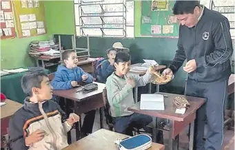  ?? ?? El director de una escuela de Minga Guazú distribuye tortillita­s a falta de almuerzo escolar.