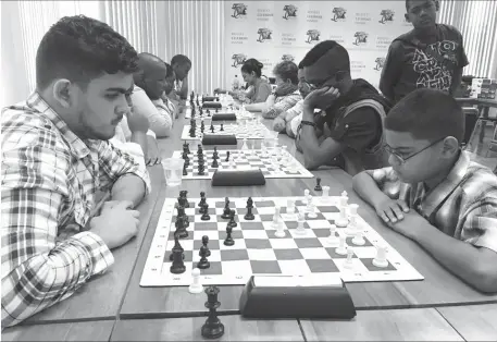  ??  ?? Roberto Neto, 19, (left) is a member of the 2016 Guyana Olympiad chess team. A newcomer to the game, he enjoyed some robust successes by defeating the senior and junior national champions on occasion. Although he only began playing the game in 2010, Neto has been competing regularly in tournament­s and has become a prominent fixture in competitio­ns. In this photograph, he faces St Stanislaus’ student Gansham Alijohn in a recent tournament.