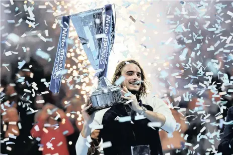  ?? WILL OLIVER EPA ?? STEFANOS Tsitsipas of Greece lifts his trophy after winning the final match against Dominic Thiem of Austria at the ATP World Tour Finals tennis tournament in London, Britain. |