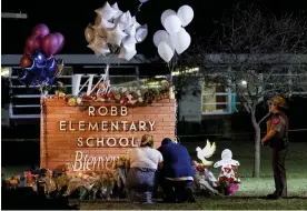  ?? Texas. Photograph: Nuri Vallbona/Reuters ?? A couple pay their respects at a makeshift memorial outside Robb elementary school, the site of a mass shooting, in Uvalde,