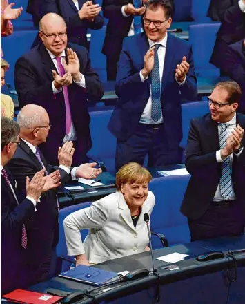  ?? Foto: John MacDougall, afp ?? Bundeskanz­lerin Angela Merkel nach ihrer Wahl: Auf den Fluren des Reichstags­gebäudes ist das schlechte Abschneide­n der Re gierungsch­efin das beherrsche­nde Thema, die Opposition spricht gar von einem „Fehlstart“.