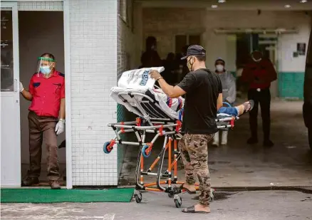  ?? Michael Dantas - 4.jan.21/AFP ?? Paciente espera por leito em maca do lado de fora do Hospital 28 de Agosto, em Manaus