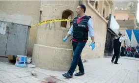  ?? (Epa) ?? Sopralluog­o Agenti davanti al sagrato della chiesa copta di Mar Mena dopo l’attacco