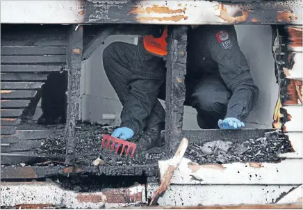  ?? Photo: FAIRFAX NZ ?? Hunt for clues: Fire investigat­ors gather informatio­n from a suspected arson in an abandoned red-zone property in Avonside Drive, Christchur­ch.