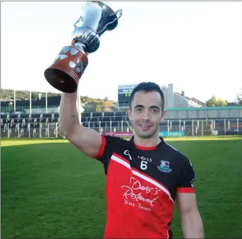  ??  ?? Captain Neil Ewing lifts the trophy following his side’s victory.