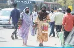  ??  ?? DHAKA: Women wearing facemasks amid fears of the spread of COVID-19 novel coronaviru­s, walk through a street in Dhaka. —AFP