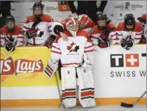  ?? RYAN REMIORZ, THE CANADIAN PRESS ?? Dejected Canadian goalie Emerance Maschmeyer is comforted following the United States’ 1-0 victory in overtime at the women’s world hockey championsh­ips Monday.