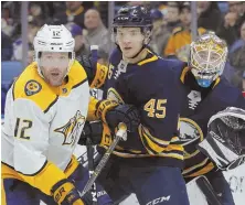  ?? AP PHOTO ?? TRIO OF LOOKERS: Buffalo's Brendan Guhle (center) and Nashville forward Mike Fisher battle for position during the second period last night in Buffalo, N.Y.