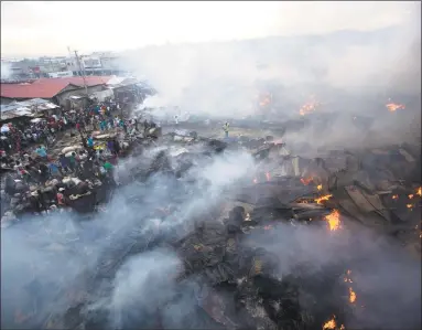  ?? Dieu Nalio Chery / Associated Press ?? The city's biggest local rice and beans market smolders after a fire, in of Port-au-Prince, Haiti on Tuesday. The entire market, where they sell local rice, black beans, onions with other grains and perishable­s was destroyed in the blaze during the...