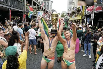  ?? Pictures: Nic Bothma/Reuters ?? Faf de Klerk and his teammates, above, celebrated in fine form outside the Cape Town City Hall, and in the city’s jampacked streets fans celebrated the joy of victory by proudly displaying the national colours, left,