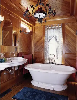  ??  ?? RIGHT This fabulous Eastlake-style bathroom clad in cherry was based on Victorian paneled rooms in the Stick Style Sanford–Covell House in Newport, R.I. The gaslight-era chandelier is ca. 1880, sconces 1870. OPPOSITE In this revival bath, the medicine cabinet, high-tank toilet, and leaded glass are salvage items. The hex-tile floor is a reproducti­on.