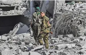  ?? (AFP) ?? Members of the Syrian Democratic Forces, backed by US special forces, make their way through the rubble on the western frontline of Raqa on October 8