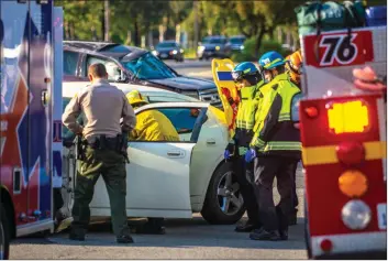  ?? Austin Dave/ The Signal ?? Santa Clarita Valley first responders tend to a woman who was injured Wednesday in a car crash in Saugus.