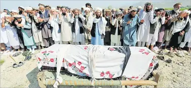  ?? Picture: REUTERS ?? Relatives and residents pray at the funeral ceremony of one of the victims in Khogyani district of Nangarhar province, Afghanista­n on Thursday.