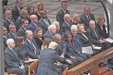  ?? — Washington Post photo by Matt McClain ?? President Donald Trump and first lady Melania Trump greet former President Barack Obama and Michelle Obama at the state funeral for former President George H.W. Bush at the National Cathedral.