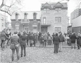  ?? THE CANADIAN PRESS ?? Mourners gather Friday in front of the Montreal home of legendary singer and poet Leonard Cohen, who died this week at 82.