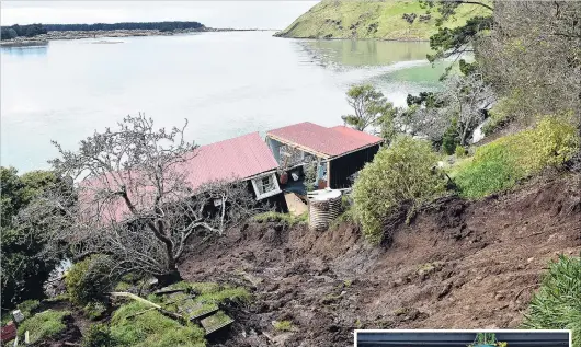  ?? PHOTOS: PETER MCINTOSH ?? Destroyed . . . A slip tore through a cottage in Cape Saunders Rd, splitting it in two and knocking it off its piles. Right: Harington Point resident Sherrie Valli wades through the flood water which surrounds her Harington Point Rd home yesterday.