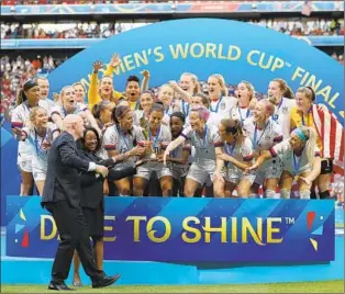  ?? Elsa Getty Images ?? FIFA LEADERS (presenting the Women’s World Cup trophy on Sunday) could atone for their long-standing sexism with a reinvented World Cup that combines men’s and women’s contests.