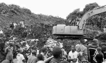  ??  ?? An excavator operates at the site of a mudslide at a rubbish landfill in the Dar Es Salam neighbourh­ood, on the outskirts of the capital Conakry, Guinea. — Reuters photo