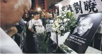 ??  ?? ►► Activistas lloran la muerte del premio Nobel chino Liu Xiaobo, ayer en Hong Kong.
