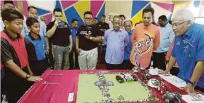  ?? FILE PIC ?? Datuk Seri Hamzah Zainudin looking at a student’s invention during the IP Funtastic programme organised by MyIPO at a school last year. The Domestic Trade, Cooperativ­es and Consumeris­m Ministry plans to cooperate with the Education Ministry to...