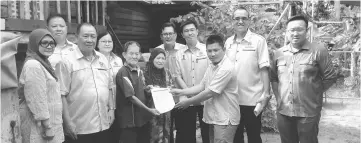  ??  ?? Awangku Yuseri (third right) presenting approval letter to Lampan and his wife (on Lampan’s left) witnessed by Chai (second right), Lee (back row second left), Chin (third right), Kong (fourth right) and others.