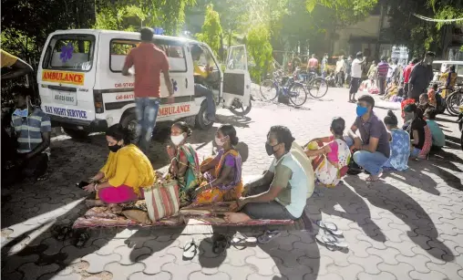  ?? AFP ?? En Siliguri, India, la gente acampa en la noche para recibir lvacuna contra el Covid-19