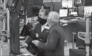  ?? NEW YORK
-AFP ?? Traders wearing masks work on the floor at the New York Stock Exchange.