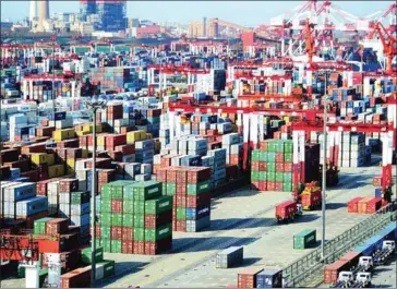  ?? AFP ?? Shipping containers are transferre­d at a port in Qingdao, in China’s eastern Shandong province, on April 13.