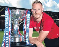  ?? Picture: SNS. ?? Adam Rooney gets his hands on the Betfred Cup yesterday as he looks forward to tonight’s quarter-final clash with Motherwell at Fir Park.
