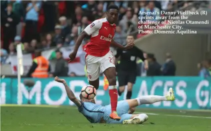  ??  ?? Arsenal's Danny Wellbeck (R) sprints away from the challenge of Nicolas Otamendi of Manchester City. Photo: Domenic Aquilina
