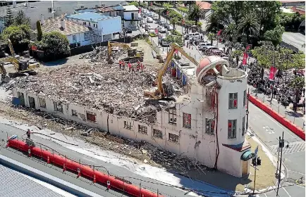  ?? PHOTO: MYTCHALL BRANSGROVE/STUFF ?? The dome of Timaru’s Hydro Grand Hotel is pulled down as a crowd watches from across the road.