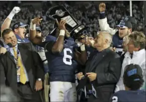  ?? CHRIS KNIGHT — THE ASSOCIATED PRESS ?? Penn State’s Malik Golden (6) hoists the Big Ten East division trophy after defeating Michigan State 45-12 in an NCAA college football game in State College, Pa., Saturday.