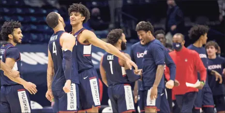  ?? Albert Cesare / Associated Press ?? UConn’s Andre Jackson, third from left, and Tyrese Martin (4) celebrate after Saturday’s win over Xavier in Cincinnati.