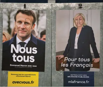  ?? BOB EDME — THE ASSOCIATED PRESS ?? Presidenti­al campaign posters of French President and centrist candidate for reelection Emmanuel Macron and far-right presidenti­al candidate Marine Le Pen are seen in Salies de Bearn, southweste­rn France, on Saturday.