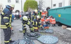  ??  ?? Die Wehrleute bereiten die Hebekissen zum Anheben des Containers vor, währenddes­sen versorgen Notarzt und Mitglieder der SEG den eingeklemm­ten Verletzten.