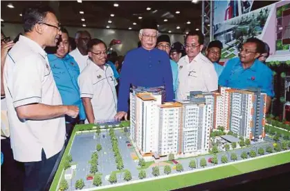  ?? [FOTO AMRAN HAMID/BH] ?? Najib melihat replika projek PPR selepas pelancaran majlis bersama rakyat di Mahsuri Internatio­nal Exhibition Centre (MIEC), di Padang Matsirat, semalam.