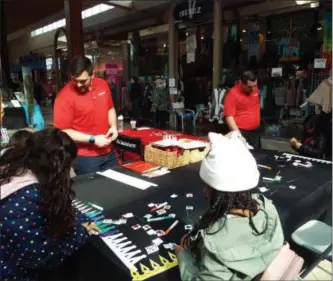  ?? TYLER RIGG —THE NEWS-HERALD ?? State Farm representa­tives interact with kids as they craft decorative crowns during the 2019 Home &amp; Lifestyle Expo March 2 at Great Lakes Mall in Mentor.